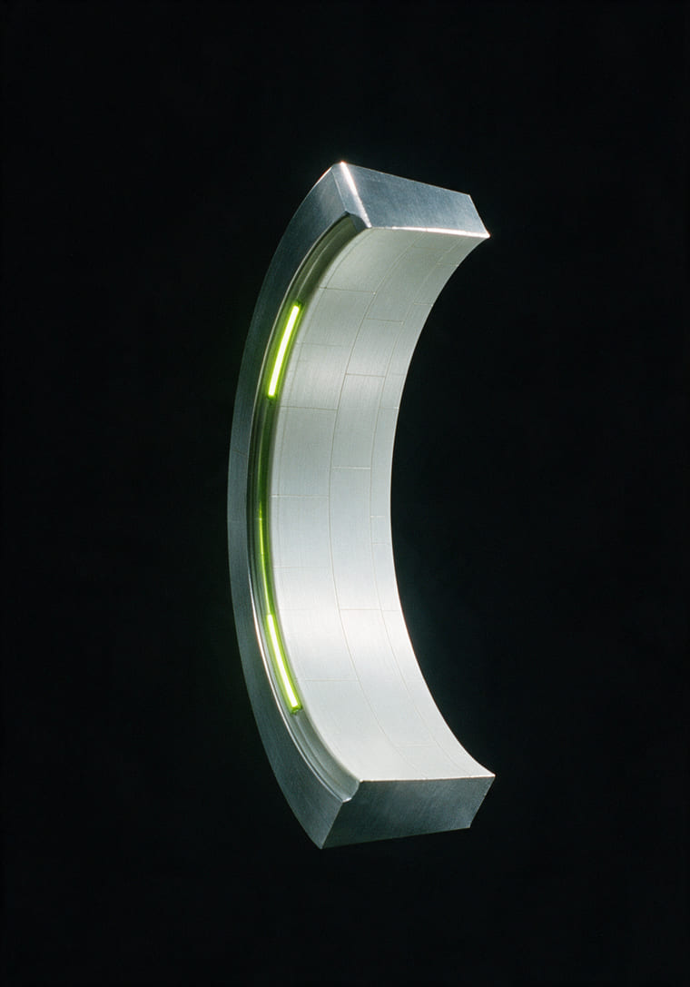 A curved segment of a machined ring with a lime light strip, on black
